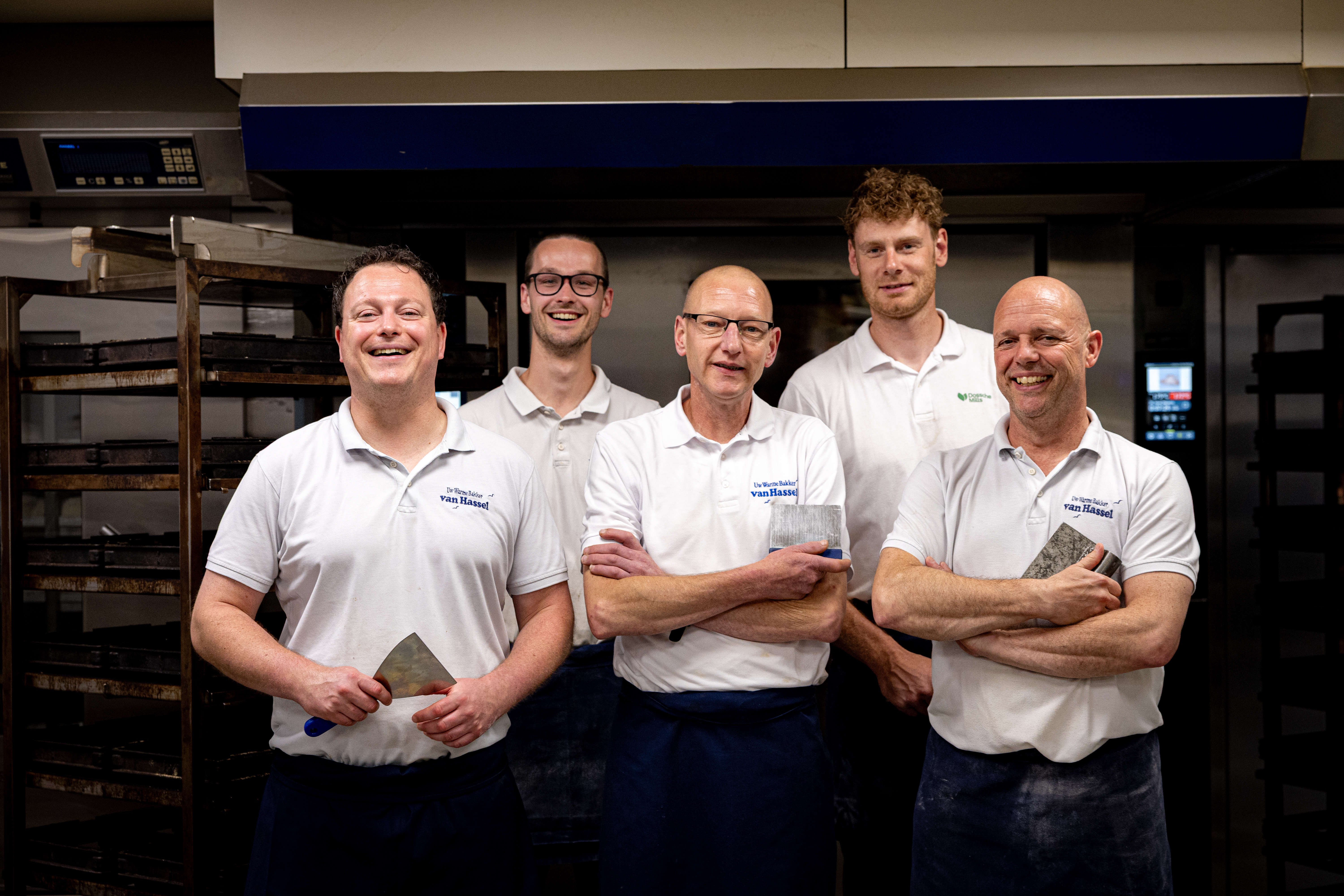 Het bakkersteam van Van Hassel voor de oven met gereedschap in de hand